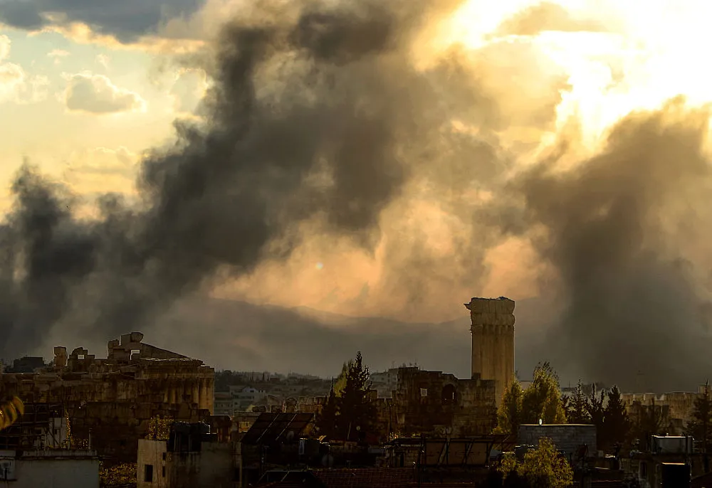 Thick plumes of smoke rise behind a Roman temple complex.