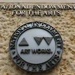 WASHINGTON, DC - JUNE 1: A logo for the National Endowment for the Arts (NEA) is displayed outside of its headquarters at Constitution Center on June, 2025 in Washington, DC. (Photo by Kevin Carter/Getty Images)