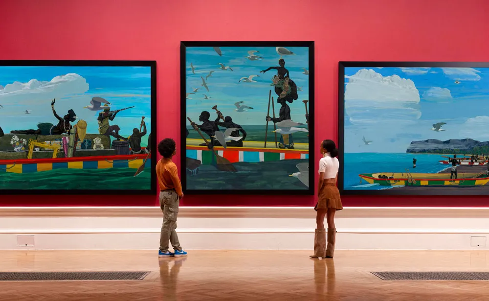Two people staring at three paintings of Black figures in a boat.