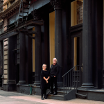 Two attractive people outside of a building in downtown New York.