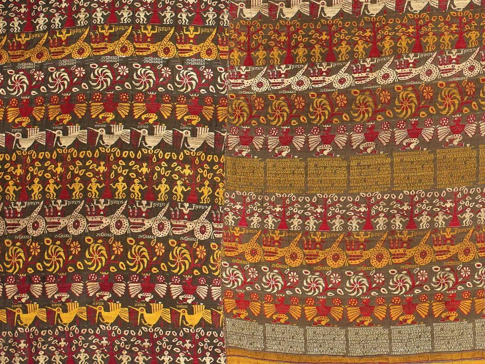 A multi-colored textile depicting whorls, flora, and figures from Hindu mythology.