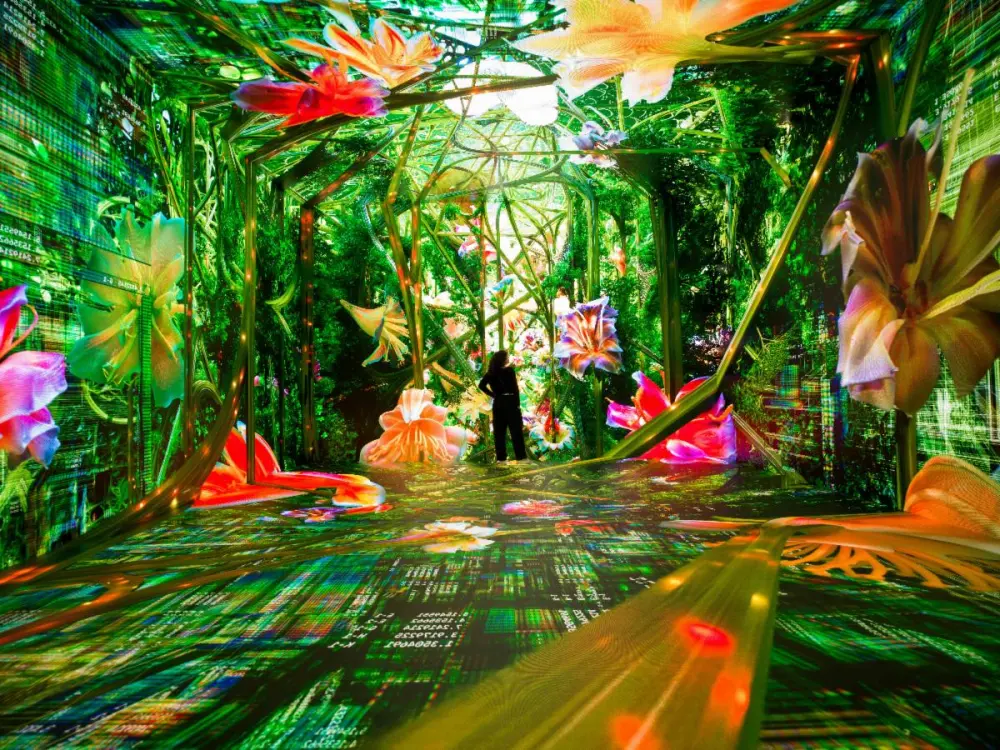 colorful immersive installation showing green plants and flowers with a person standing in the room