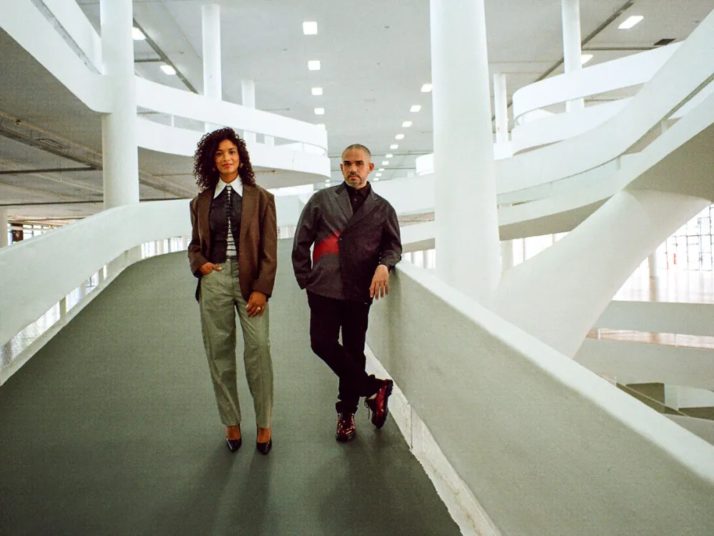 Amanda Carneiro and Raphael Fonseca stand in the Ciccillo Matarazzo pavilion in the Parque do Ibirapuera.