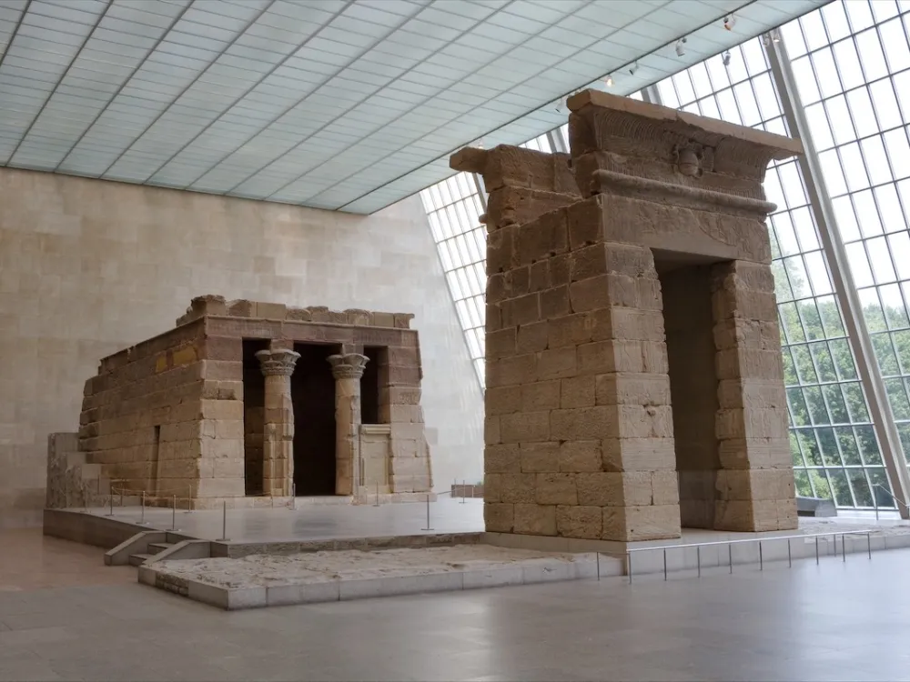 An ancient temple in a light-filled room with a large glass window.