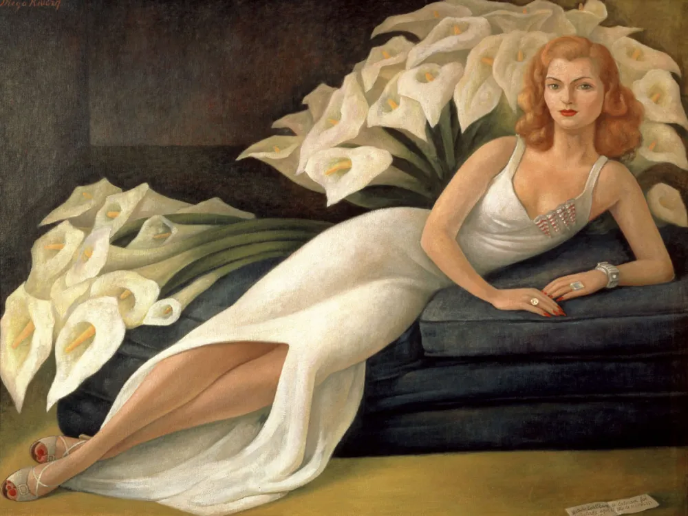 A painting of a white woman with reddish hair in a white gown, laying on a blue couch. Behind her are two large bouquets of calla lilies.