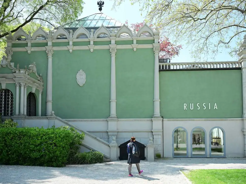A person walking in front of a pavilion with the word 