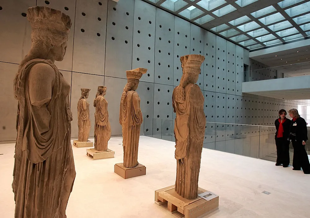 Ministry of Culture employees look at the famous caryatid statues inside the new Acropolis Museum in Athens 10 January 2008. The Greek president visited the new museum  that is expected to be ready to open its gates to the public in early 2008.AFP PHOTO/Louisa Gouliamaki (Photo credit should read LOUISA GOULIAMAKI/AFP via Getty Images)