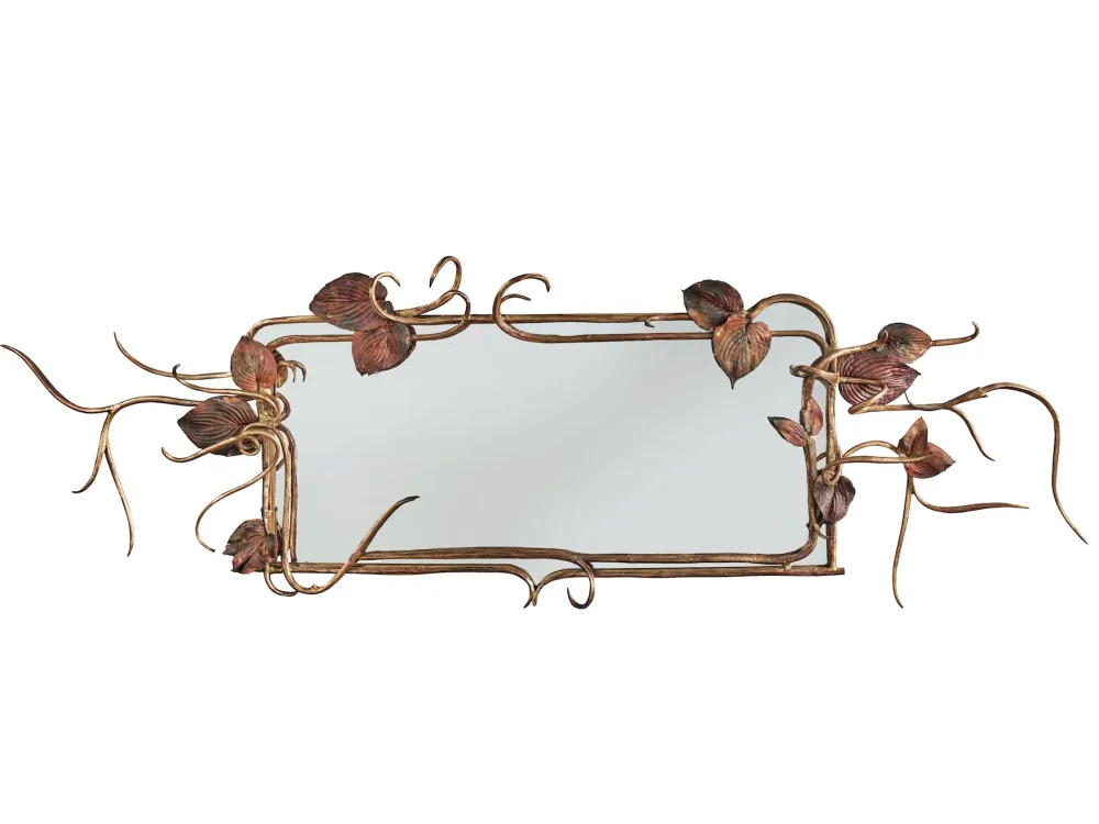 A mirror with gold leafs on its frame.