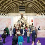 Aerial view of an art fair, with a purple carpet and pink installation in the foreground.