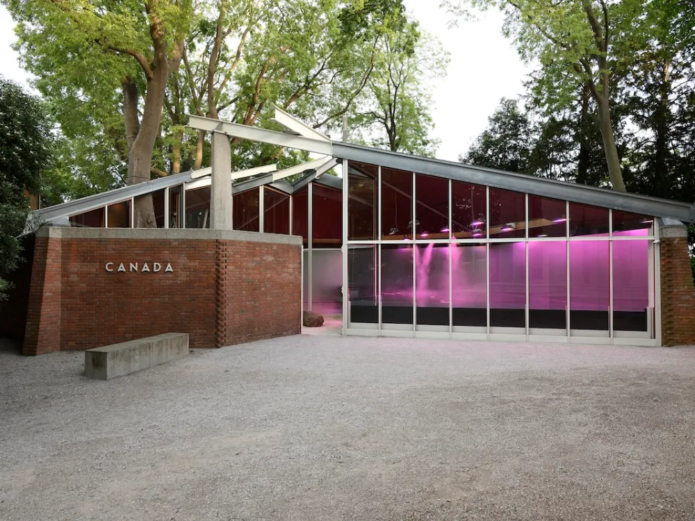 A glass building with purple lights and a brick facade with lettering that reads 