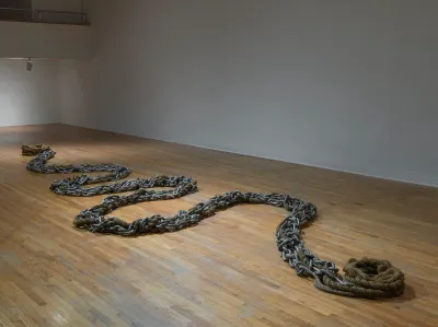 A sculpture composed of a zigzagging chain that culminates in rope at one end.