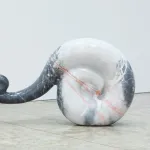 A curlicuing sculpture on the floor made of marble.