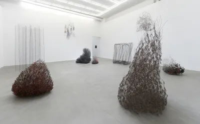 A group of wire sculptures in a gallery.