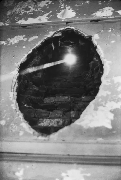 A hole in a brick wall that allows sunlight into a room.