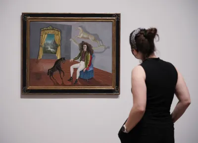 A woman staring at a painting of a woman sitting in front of a floating rocking horse.