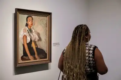 A person walks past a painting by Laura Wheeler Waring titled Girl in Green Cap during a press preview of “The Harlem Renaissance and Transatlantic Modernism” exhibit at The Metropolitan Museum of Art (The Met) on February 20, 2024 in New York. (Photo by ANGELA WEISS / AFP) / RESTRICTED TO EDITORIAL USE - MANDATORY MENTION OF THE ARTIST UPON PUBLICATION - TO ILLUSTRATE THE EVENT AS SPECIFIED IN THE CAPTION