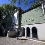 exterior of a building with a green facade that says 