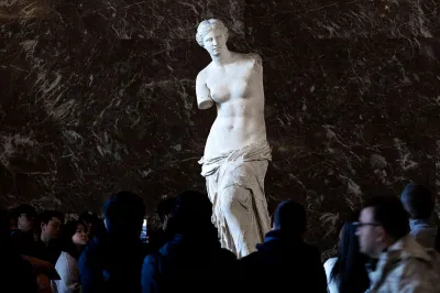 Visitors watch the ancient Greek marble statue the 