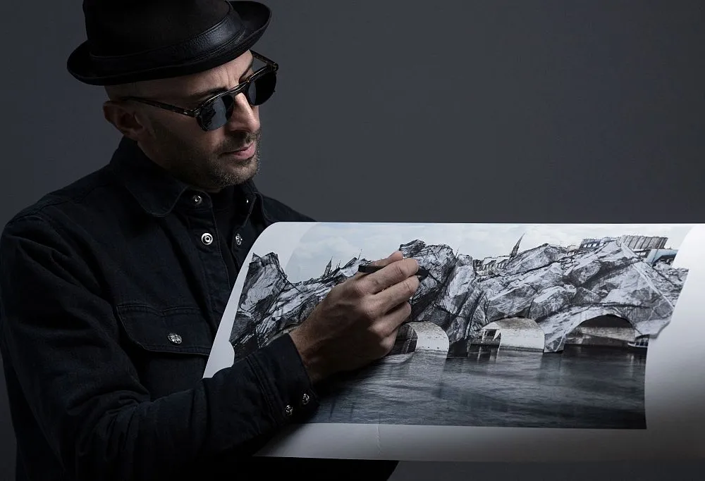 TOPSHOT - French photographer and street artist JR, poses in his Paris studio on November 26, 2025, presenting "The Cave of the Pont Neuf," the artwork he will create as a tribute to Christo and Jeanne-Claude, transforming the Pont Neuf forty years after the wrapping of Paris