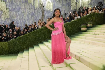 A woman in a pink dress on a staircase.