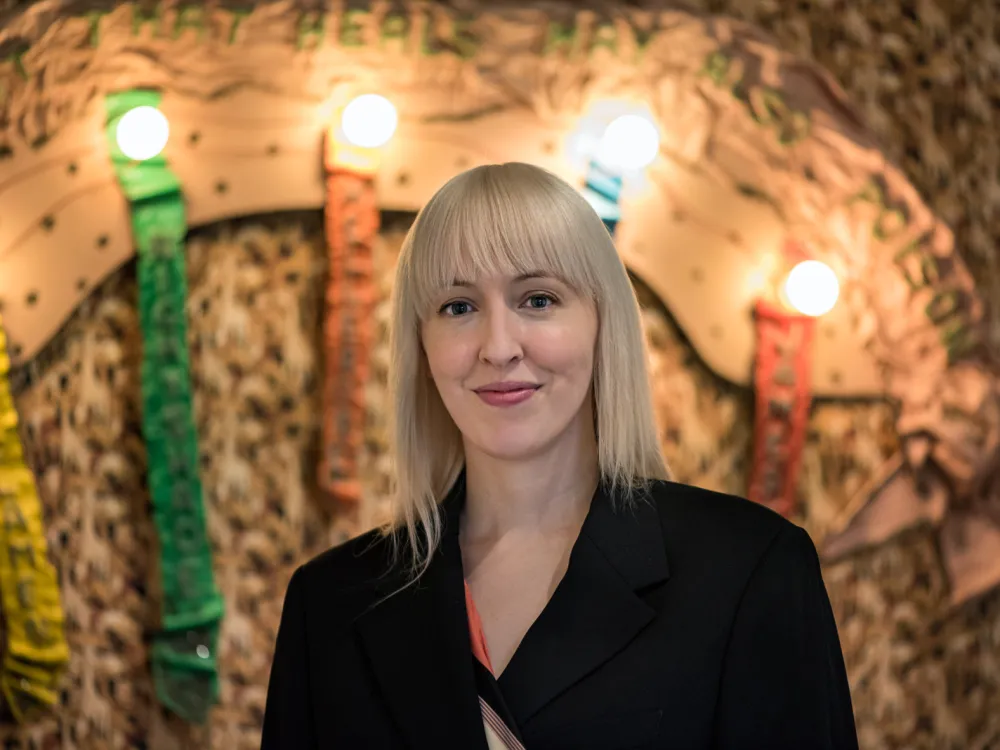 A blonde white woman wearing black smiles for the camera