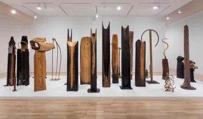 An array of totem-like wood sculptures.