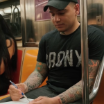 A photograph of a man drawing on the subway.