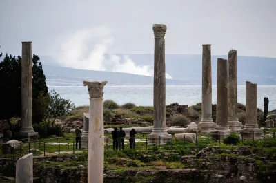 This photograph taken on March 23, 2026, shows smoke as it rises from the site of an Israeli air strike at the background of the archaeological site of the ruins of the Phoenician Port in the southern Lebanese city of Tyre. At the achaeological site of Al-Bass, in Lebanon