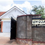 a home with a curved wall with a sign that says Umoja art gallery