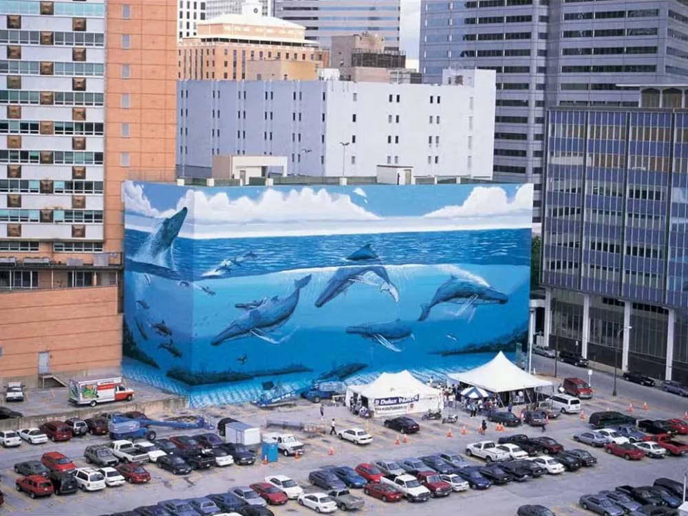 A photo shows a giant mural in Downtown Dallas depicting whales and dolphins swimming in the ocean.