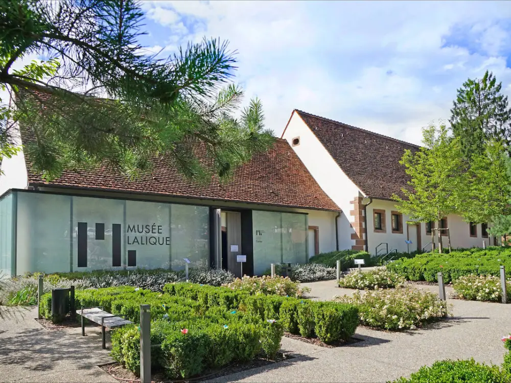 A museum with bushes in front of it.
