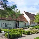 A museum with bushes in front of it.