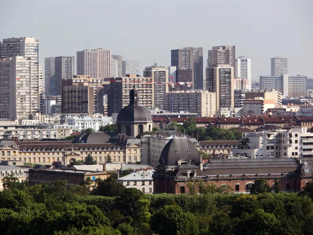 A museum sited among trees and skyscrapers.