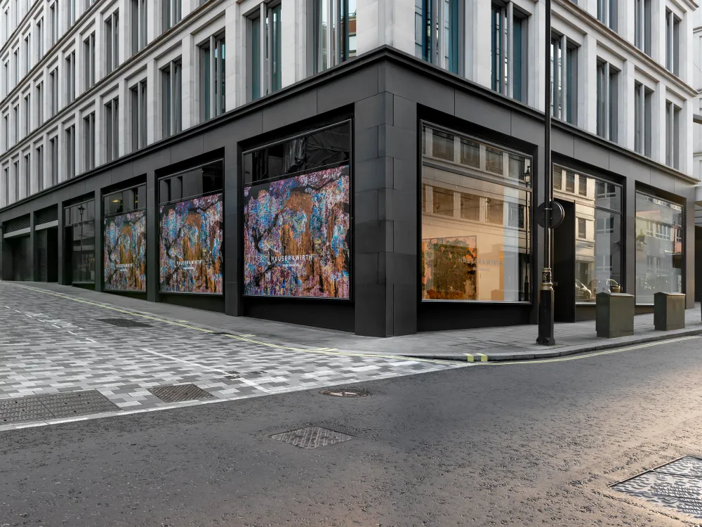 An image of a building on a corner in London. On the ground floor is an art gallery with large windows.