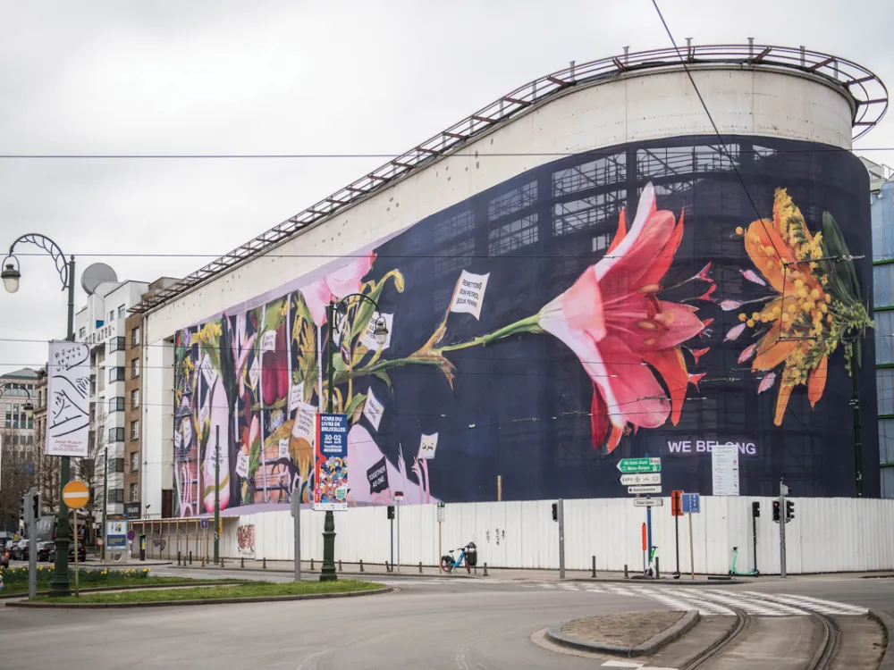 exterior view of a curved building with colorful images of flowers on the protruding wall