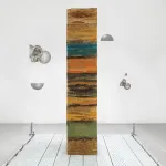 A vertical striated colorful column that appers to be made of a soft material, and is predominantly ochre.