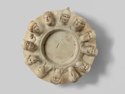 A marble circular sculpture with 12 faces.