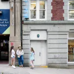 An exterior view of the Nova Scotia College of Art and Design in Halifax, Nova Scotia, with three young women standing outside