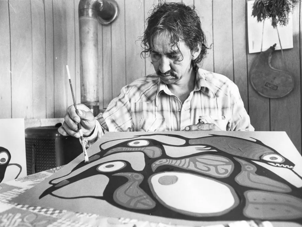 A man holding a paint brush makes a painting.