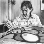 A man holding a paint brush makes a painting.