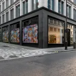 An image of a building on a corner in London. On the ground floor is an art gallery with large windows.