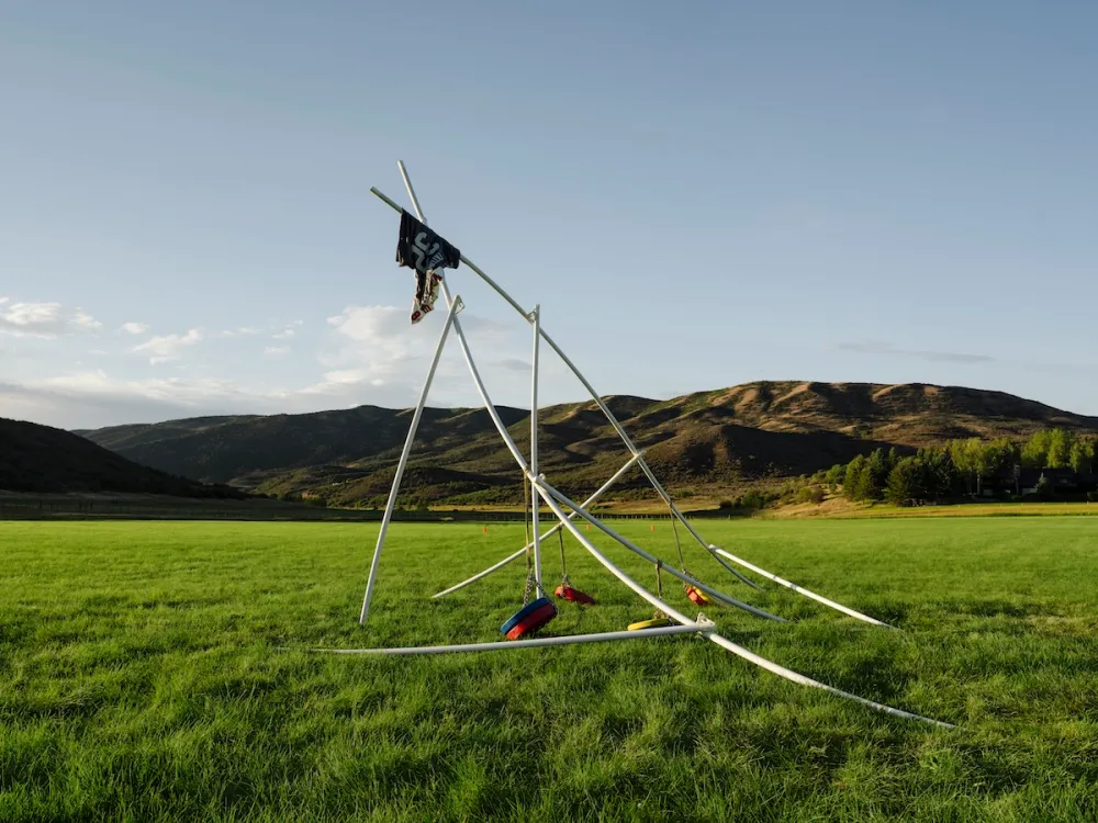 View of abstract metal sculpture against a mountainous backdrop.