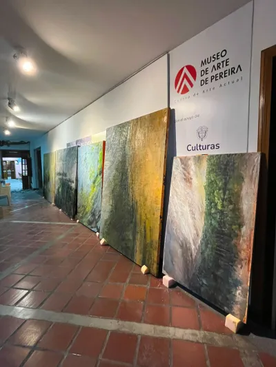Several large paintings lined up against a wall. 