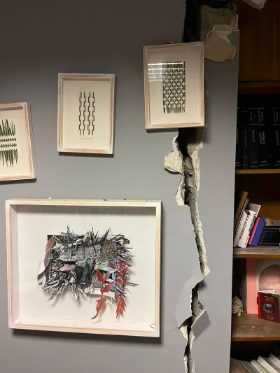 Cracked walls holding several prints. 