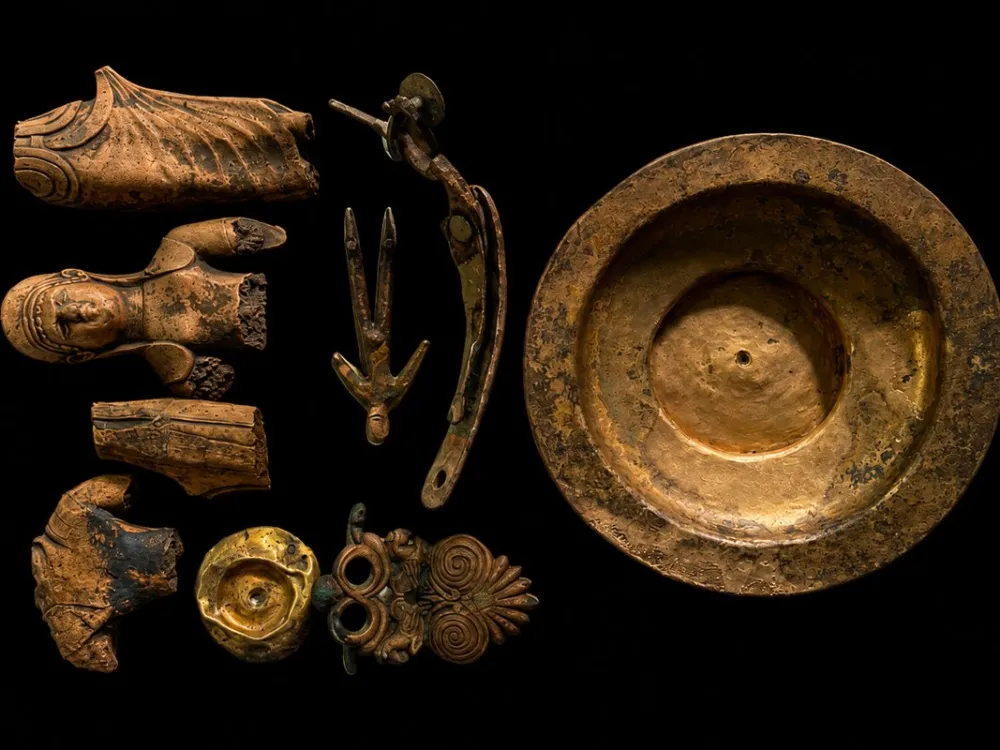 A bronze bowl by seven fragments of other bronze objects.