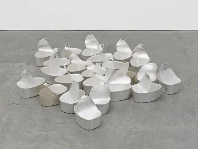 20 steel ham tins and silver leaf with natural tarnishing. The are displayed on the floor and half open.