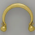 A gold collar necklace in the shape of an arc, with two orbs on the end. The arc ends with lion paws, atop each is a Pegasus.