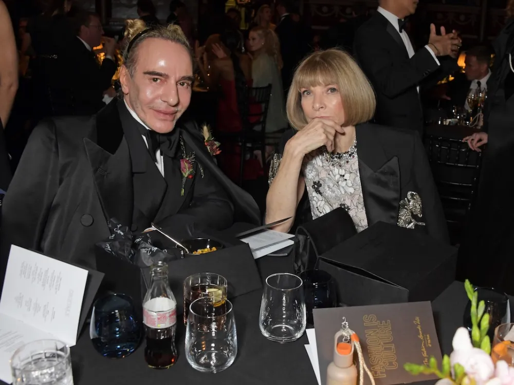 A man and a woman seated a table with glasses on it.