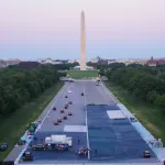 The Washington monument stands in the distance while worked apply a blue coating to the Lincoln Memorial Reflecting Pool.