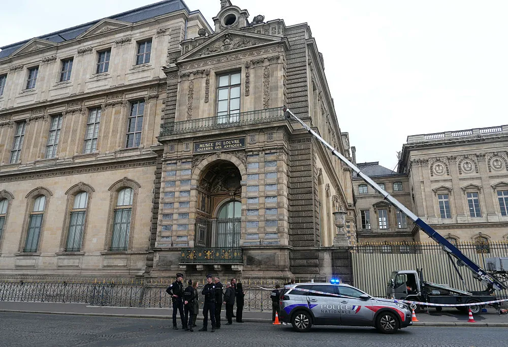 French police officers stand next to a furniture elevator used by robbers to enter the Louvre Museum, on Quai Francois Mitterrand, in Paris on October 19, 2025. Robbers broke in to the Louvre and fled with jewellery on October 19, 2025 morning, a source close to the case said, adding that its value was still being evaluated. A police source said an unknown number of thieves arrived on a scooter armed with small chainsaws and used a goods lift to reach the room they were targeting. (Photo by Dimitar DILKOFF / AFP) (Photo by DIMITAR DILKOFF/AFP via Getty Images)